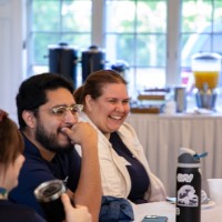 Group of GVSU Alumni smile while they sit at table together